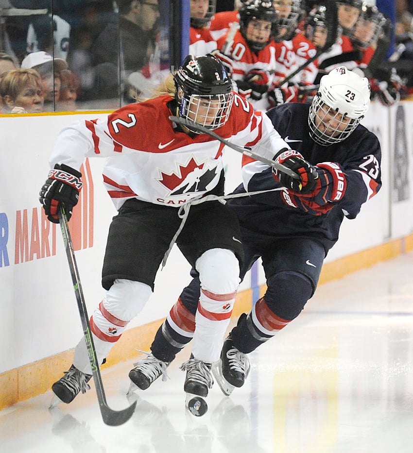 <who>Photo Credit: Lorne White/KelownaNow.com </who>Megan Agosta of Canada holds the stick of the United States' Michelle Picard. Agosta was called for a two-minute penalty in the second period.