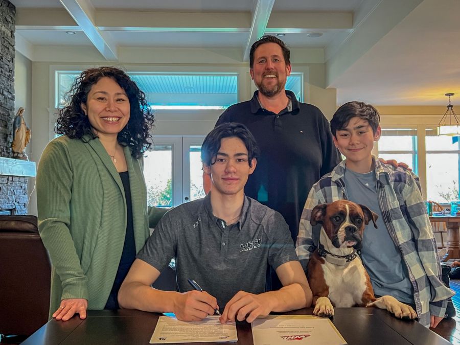Surrounded by family, Kalan Anderlini puts pen to paper.