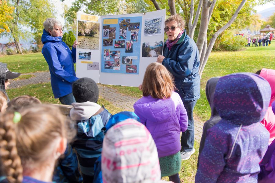 <who>Photo Credit: NowMedia</who> Lee McFadyen (right, facing camera) teaches young students about the river, the lake and the sockeye
