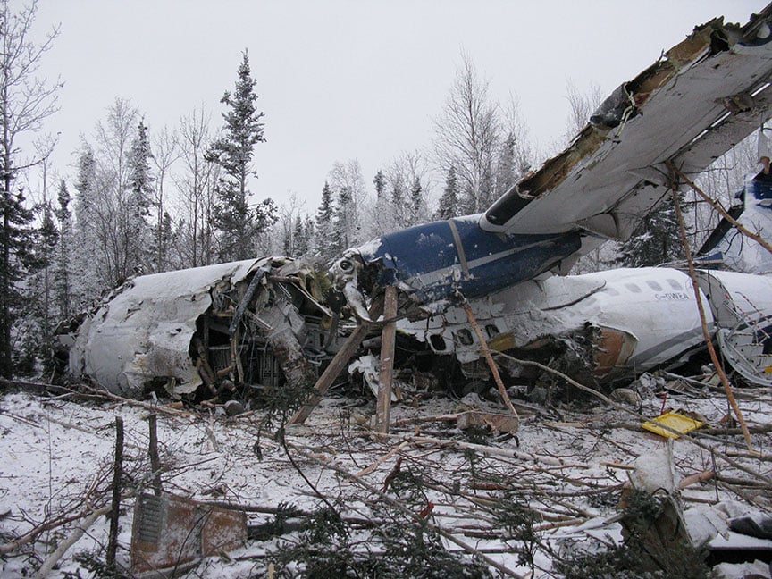 <who> Photo Credit: Transportation Safety Board </who> Left side view - front of aircraft wreckage.