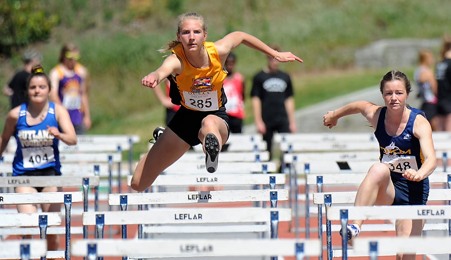 Kelowna Secondary's Madelyn Hettinga, centre, finished second to Muriel Stroda, right, of OKM in the senior hurdles.