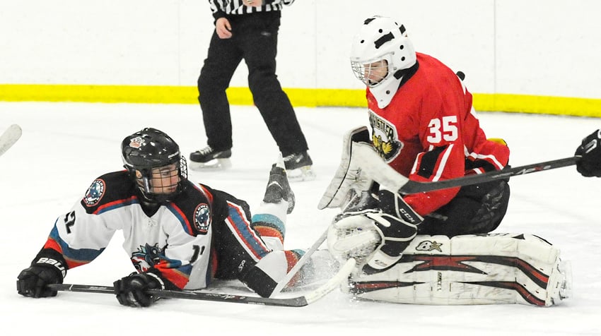 <who>Photo Credit: Lorne White/KelownaNow </who>Dylan Simpson of the Rockets in close quarters with the Whistler goaltender in pool play at the KMHA tournament.