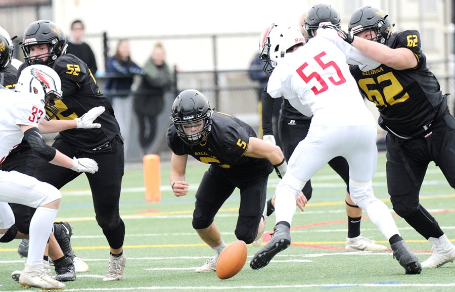 Jack Marsland (52) and Tomas Kuhn (62) occupy the Carson Graham Eagles while Owls' quarterback Nate Beauchemin attempts to recover his own fumble.