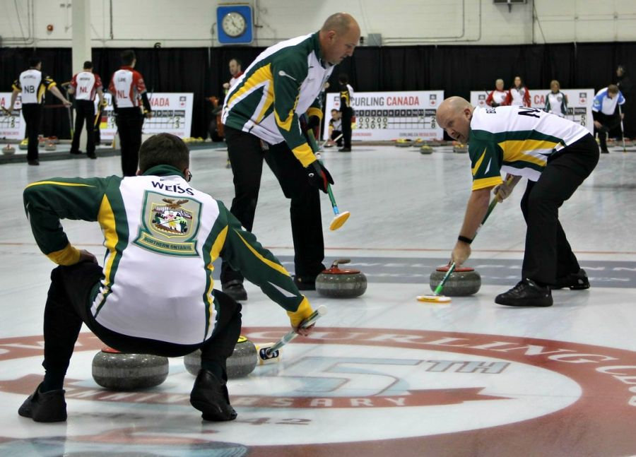 <who>Photo Credit: KelownaNow</who>Members of Team Northern Ontario guide their rock into the house.