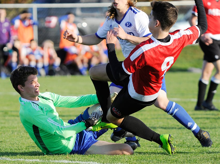 <who>Photo Credit: Lorne White/KelownaNow </who>Rutland goalkeeper Eric Dueck slides out to stop a shot by Boucherie's Yves Vercosa.