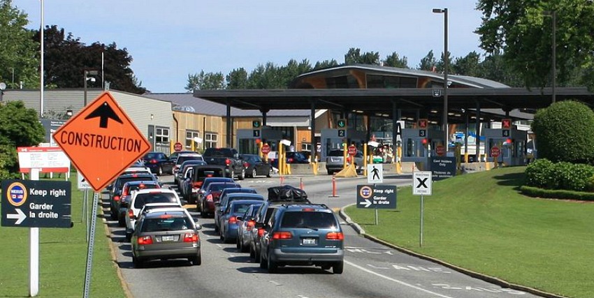 <who> Photo Credit: Wikipedia. </who> Cars approaching Canada Customs in B.C. 