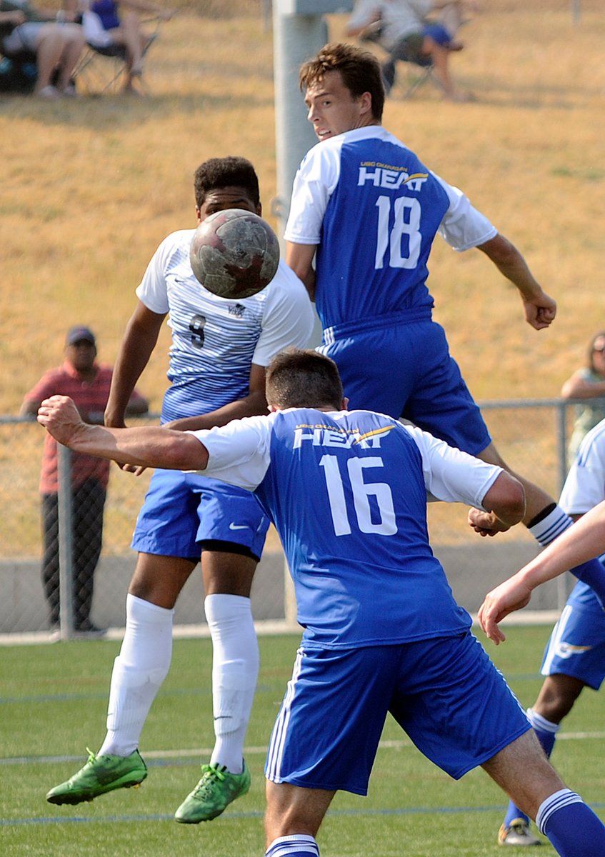 <who>Photo Credit: Lorne White/KelownaNow </who>Third-year defender, Shaun Pilcher, heads the ball out of harm's way while airborne teammate, Sam McDonald (Okanagan Mission SS), looks on.