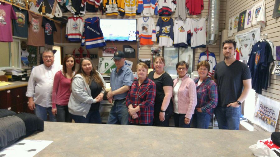 <who>Photo Credit: PentictonNow </who>The staff from Sherwood Trophies and Sherwood Signs & Graphics will be volunteering their time to print 'Broncos Strong' T-shirts that will go on sale Thursday. The employees include (from left) Brian Wyatt, Angela Venne, L. Hartway, Gord Baker, Anna Bates, Cherie Morgan, Bev Strom, Kerry Stuckel and Brett Darin.