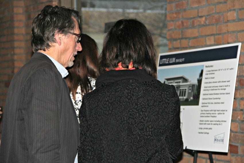 <who> Photo Credit: KelownaNow.com </who> Guests check out the micro home plans.