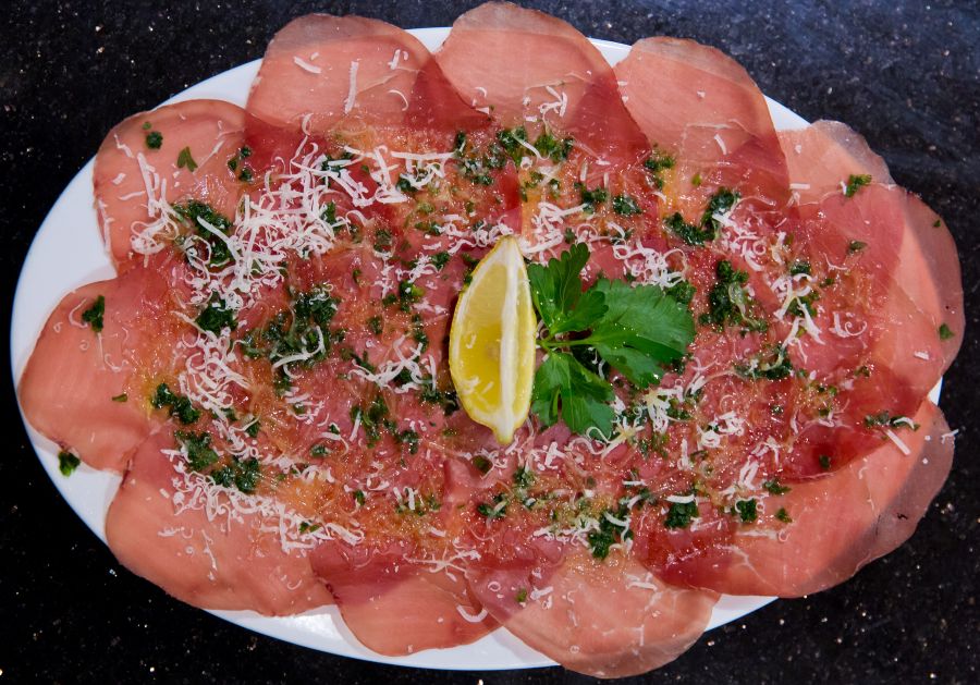 <who>Photo Credit: NowMedia</who>The Bresaola tray features beef cold cuts with olive oil, parsley, and Parmigiano flakes.