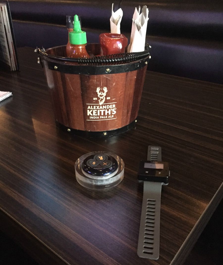 <who>Photo Credit: KelownaNow</who>The buzzer on the left is on each table and the wristband on the right is worn by every server.