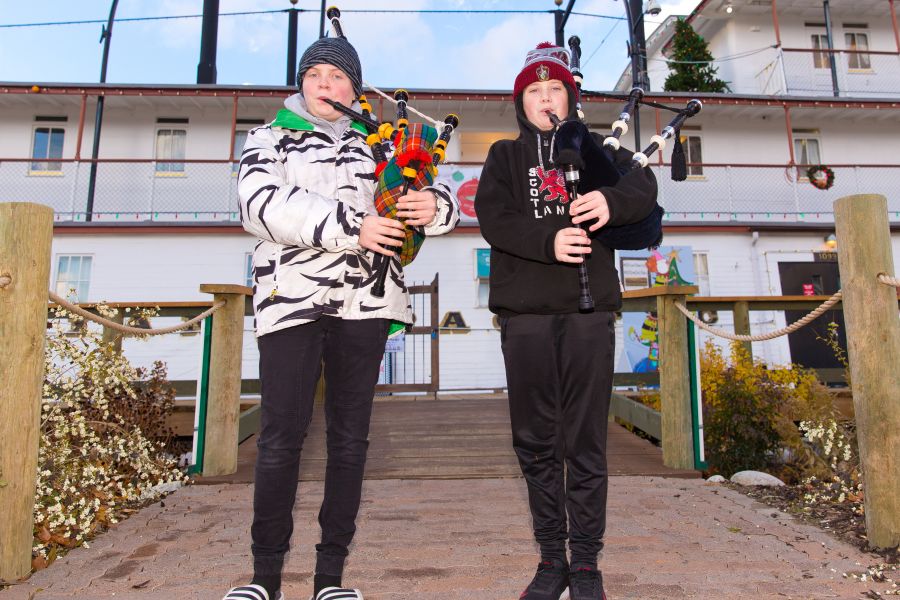 Jesse and Eli busk with bagpipes outside the Sicamous