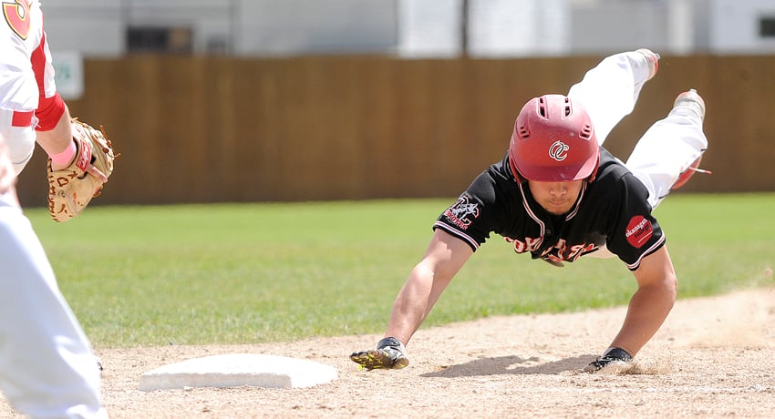 <who>Photo Credit: Lorne White/KelownaNow </who>Liam Wyatt of the OC Coyotes dives back to first base on an attempted pick-off during their 11-1 win over the U of C on Saturday.