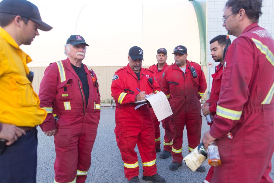 <who>Photo Credit: NowMedia</who> The squad from the Naramata Fire Department pour over their notes