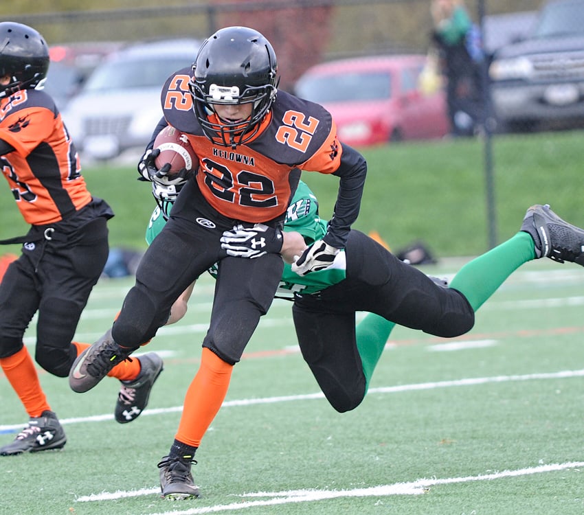 <who>Photo Credit: Lorne White/KelownaNow </who>Riley Fitzsimmons of the Kelowna Riders leaps to grab the Kelowna Lions' Risto Zimmer in the two teams' final SIFC regular-season game.