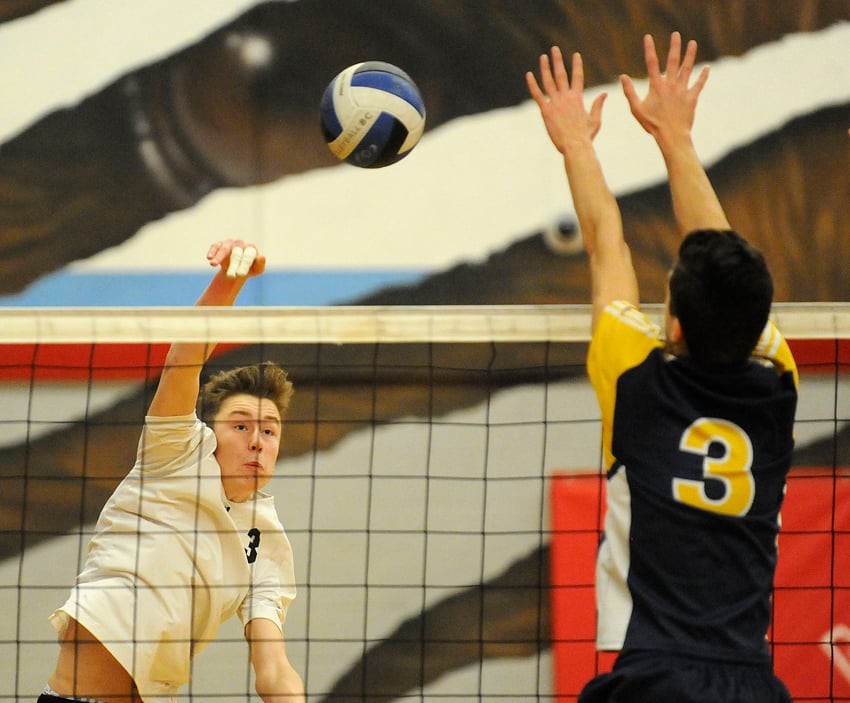 <who>Photo Credit: Lorne White/KelownaNow </who>Roan McCarthy of the George Elliot Coyotes spikes the ball past a MEI Eagles attempted block in semifinal play.