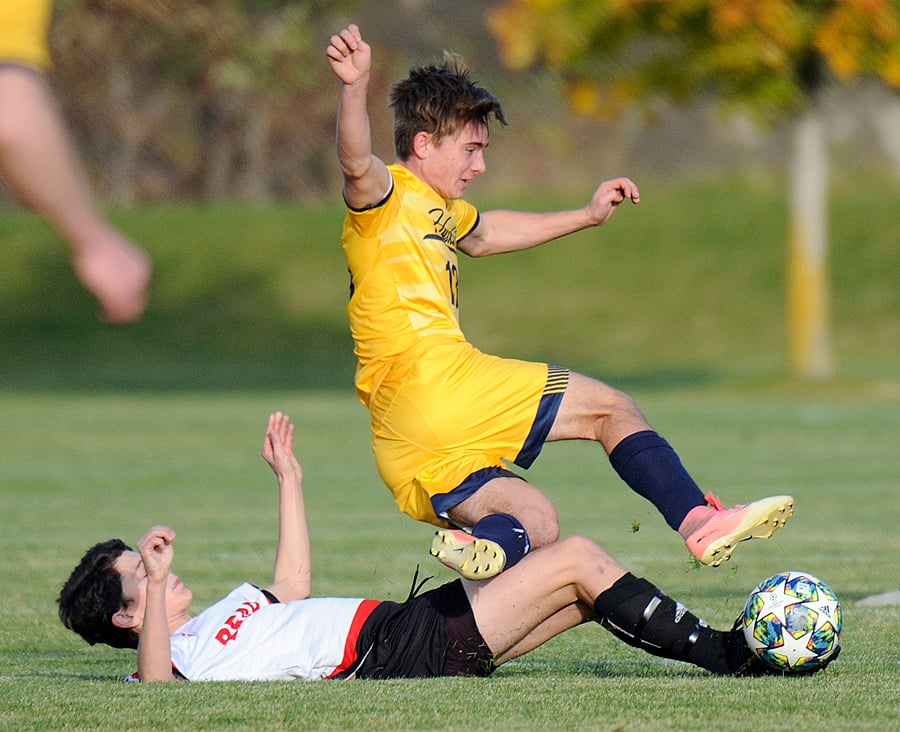 <who>Photo Credit: Lorne White/KelownaNow </who>OKM's Tobin Woodworth trips over the Bears' Jakob Love as he slides to the ball on defence.