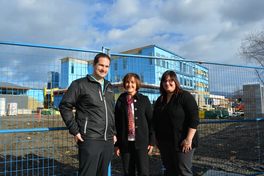<who> Photo Credit: Photo submitted by Okanagon College. </who> From L to R: Anthony Lunelli, Franca Lunelli, and Christina Bailey in front of the new Trades Training Complex under construction at Okanagan College’s Kelowna campus.