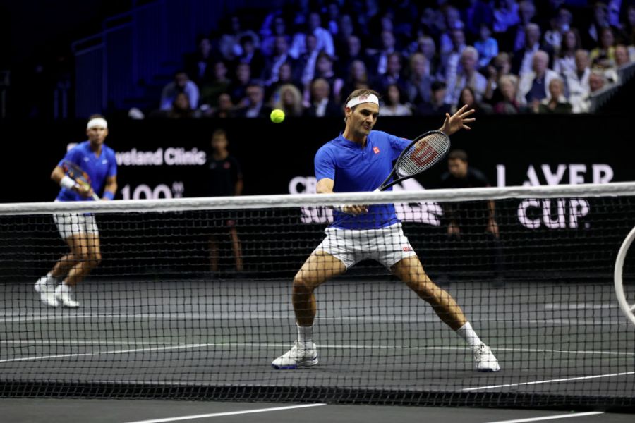 <who> Photo Credit: Getty Images </who> Federer volleys a shot during action against Frances Tiafoe and Jack Sock. 