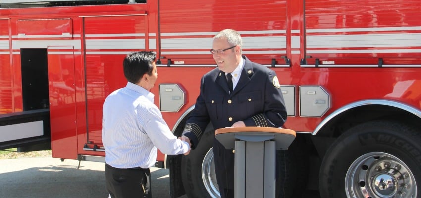 <who> Photo Credit: KelownaNow. </who> Louie shaking hands with fire Chief Jason Brolund.
