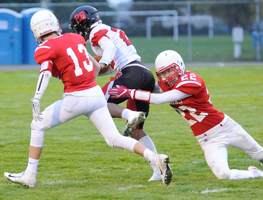 Dayton Biermann (22) and Noah Rensby converge on Abbotsford's Jalem Catlin.