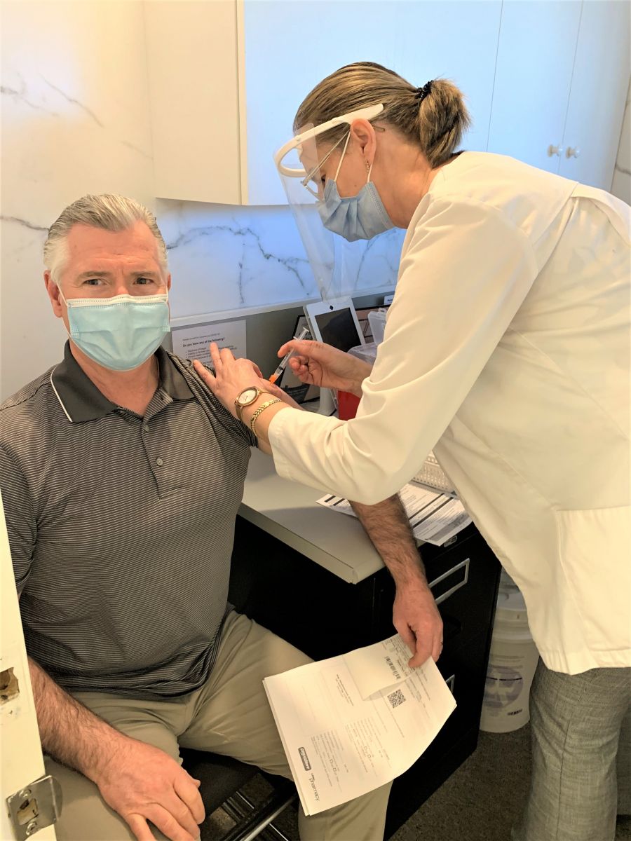 </who>KelownaNow reporter Steve MacNaull gets his first dose AstraZeneca COVID vaccine jab from pharmacist Ranka Krunic at Your Independent Grocer.