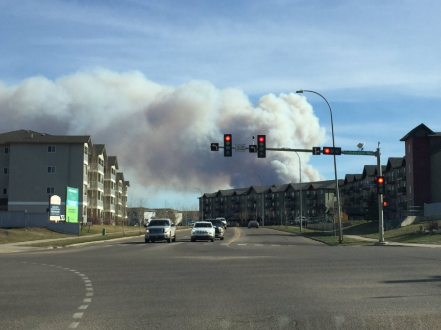 <who> Photo Credit: @RobichaudMs/ Twitter </who> Smoke can be seen just behind homes in Fort McMurray.