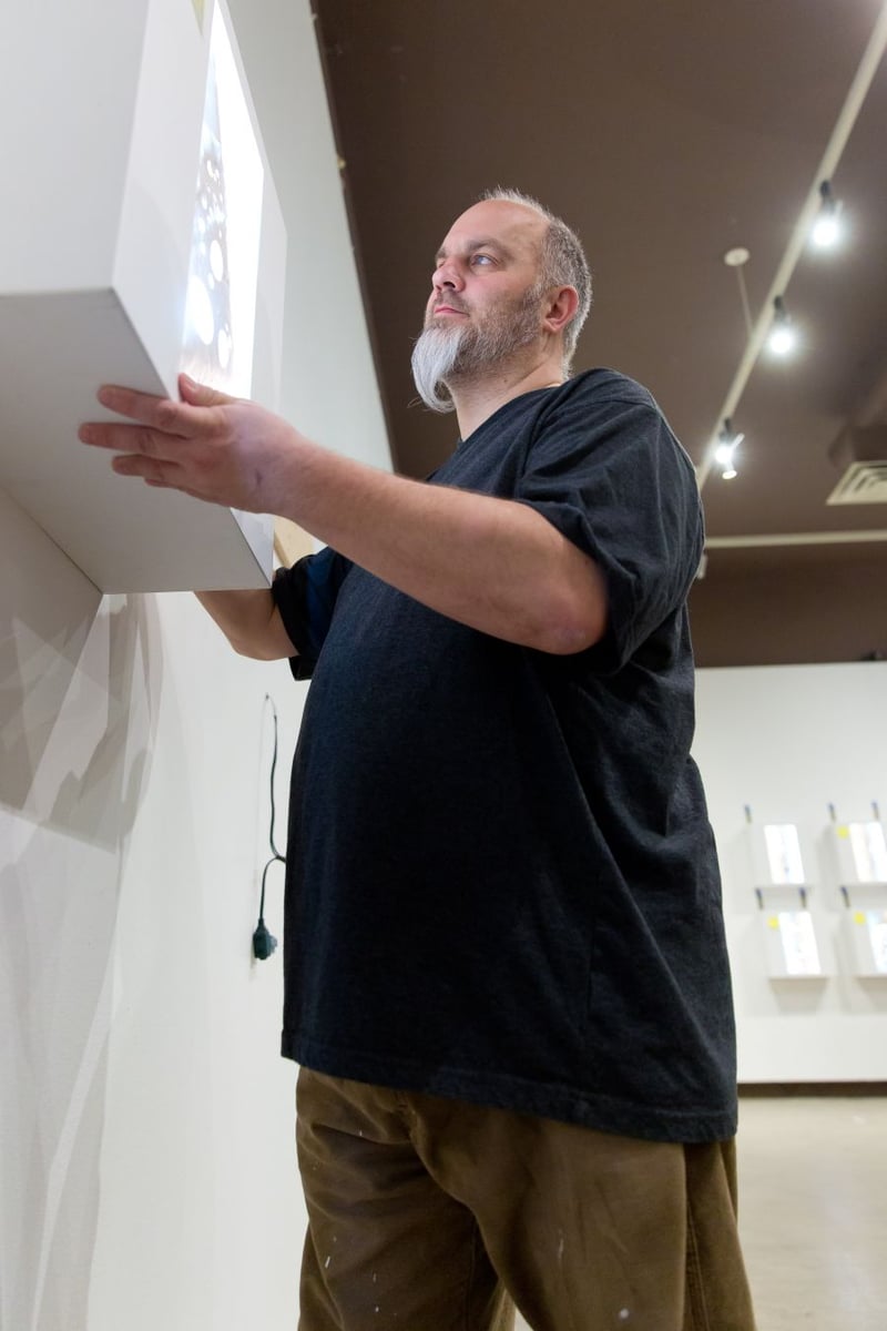 <who>Photo credit: NowMedia</who>Penticton Art Gallery curator Paul Crawford works on the installation.