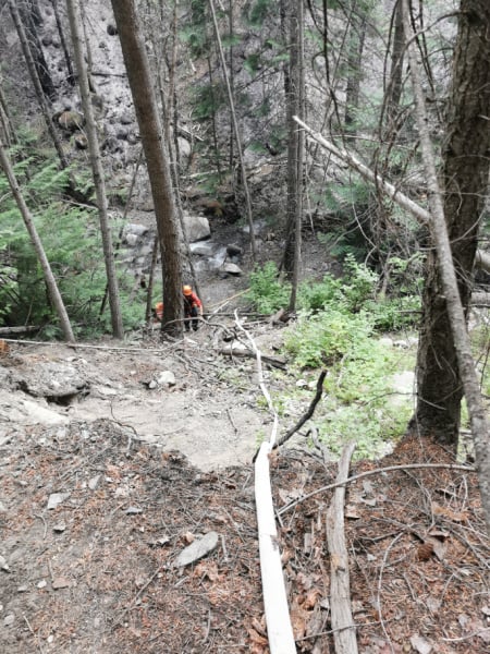 <who> Photo Credit: BCWS </who> Crews working to lay down hoses in the steep terrain.