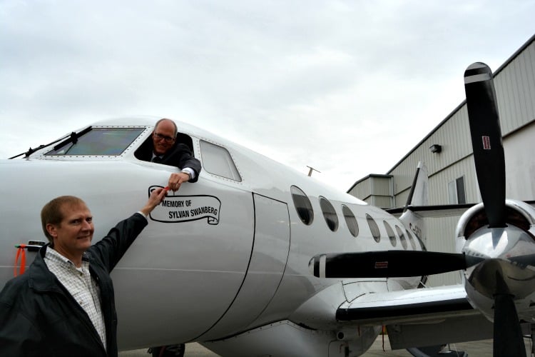 <who> Photo Credit: contributed. </who> Loran Swanberg passing Jim Hamilton the keys to the aircraft. 