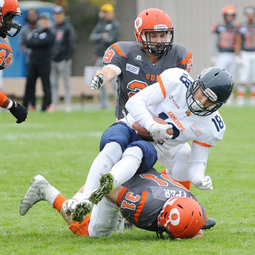 Casey Pyper slides under Broncos' receiver Tim Solypa for a tackle