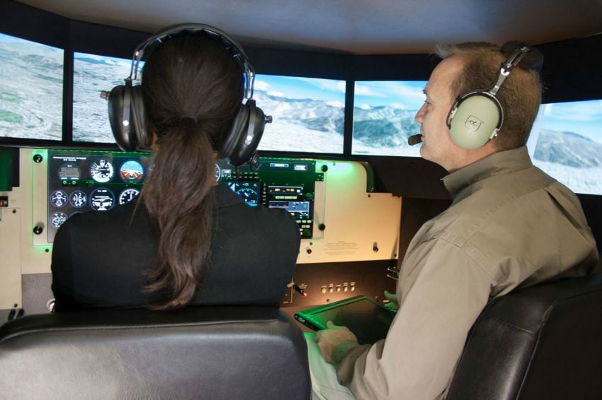 <who> Photo Credit: Redbird </who> A student is trained inside the Redbird simulator.