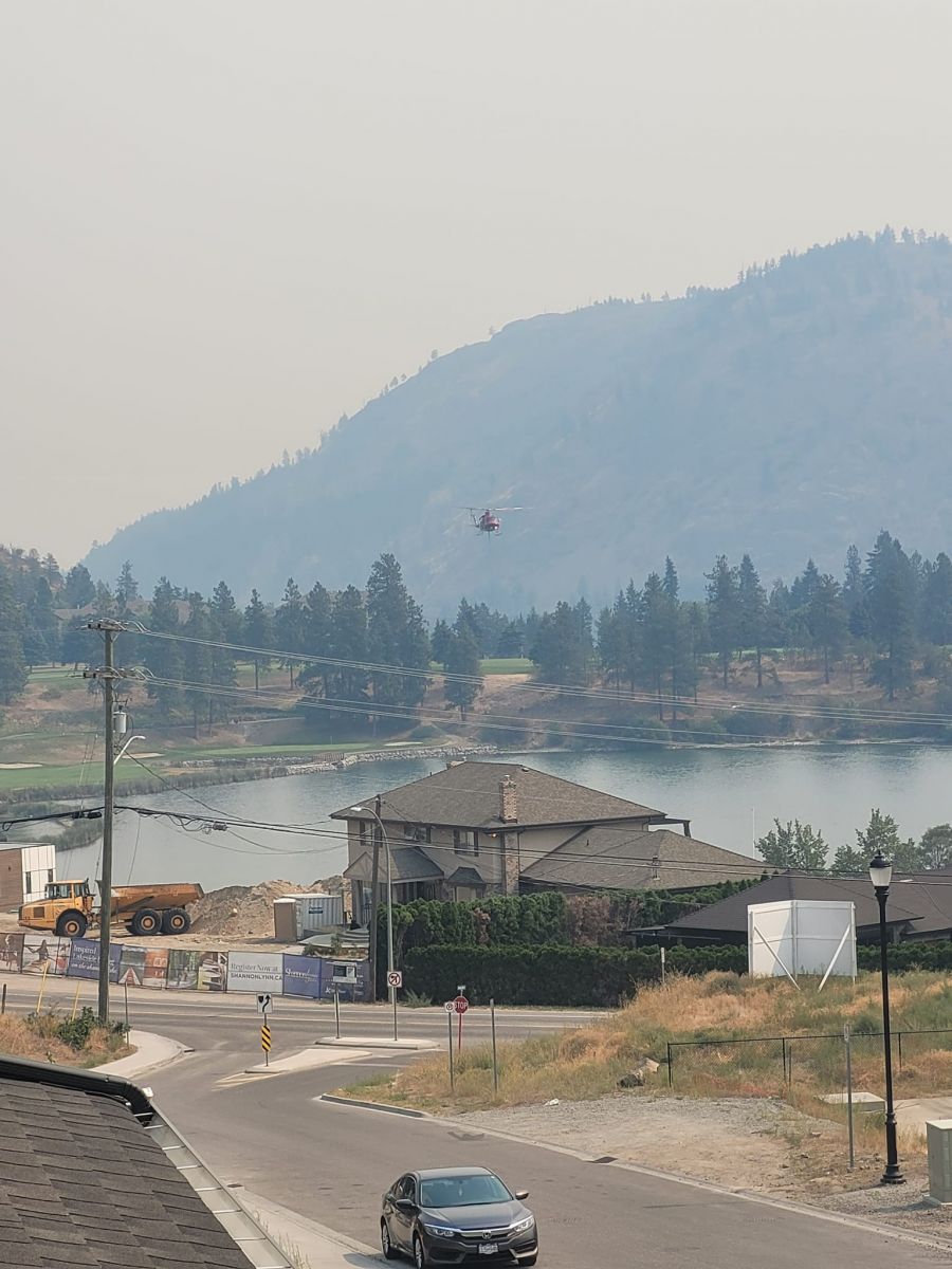 <who>Photo Credit: Jocelyn Brown</who>A helicopter buckets water from Shannon Lake Friday afternoon to action the McDougall Creek wildfire.
