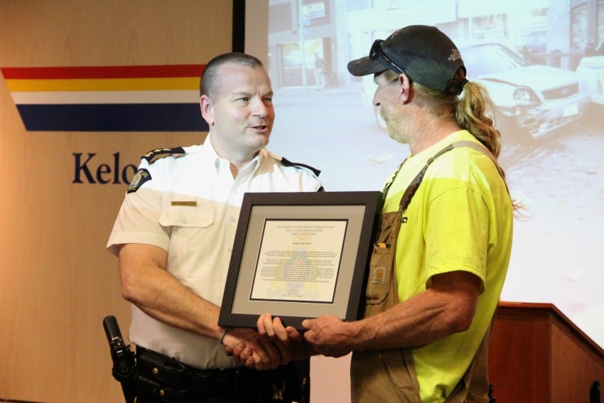 <who> Photo Credit: KelownaNow. </who> Polack (right) accepting his award from RCMP Superintendent Romanchuck (left). 