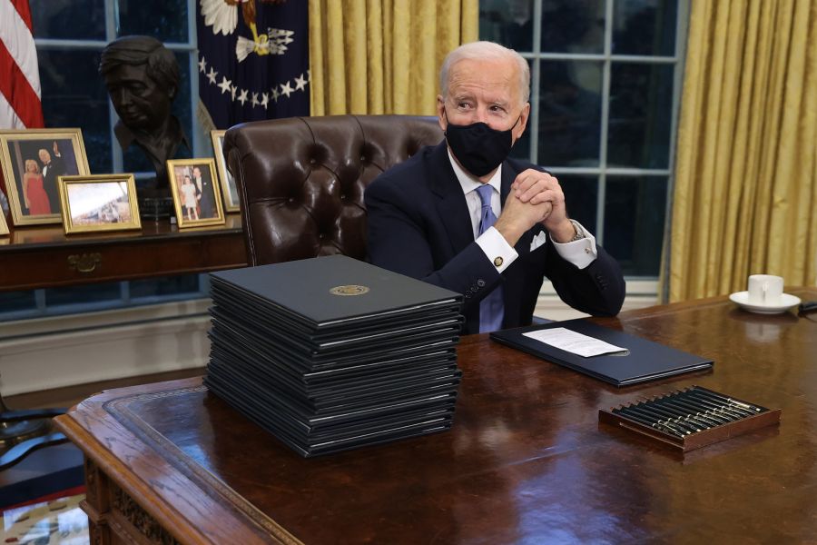 <who>Photo Credit: Getty Images</who>President Joe Biden sits in the oval office on his first day.