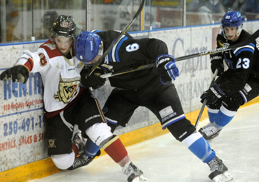 <who>Photo Credit: Lorne White/KelownaNow.com </who>Kylar Hope of the West Kelowna Warriors is taken into the boards by the Pentiction Vees Colton Poolman in the first period on Monday's BCHL playoff game.