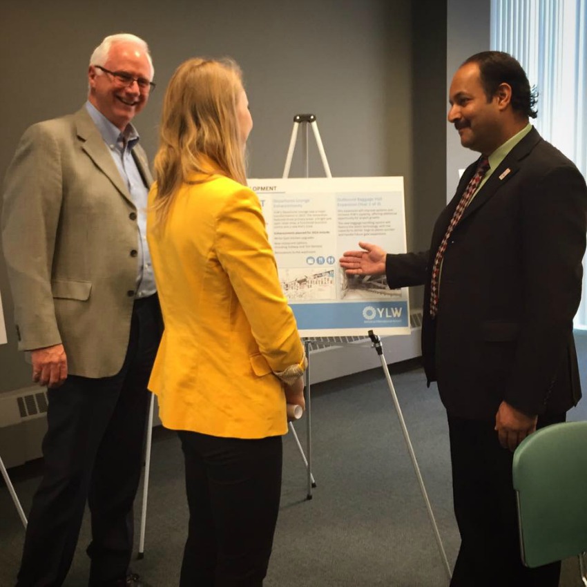 <who> Photo Credit: Kelowna International Airport </who> Sam Samaddar, Airport Director, right, speaks about the 2016 capital projects.