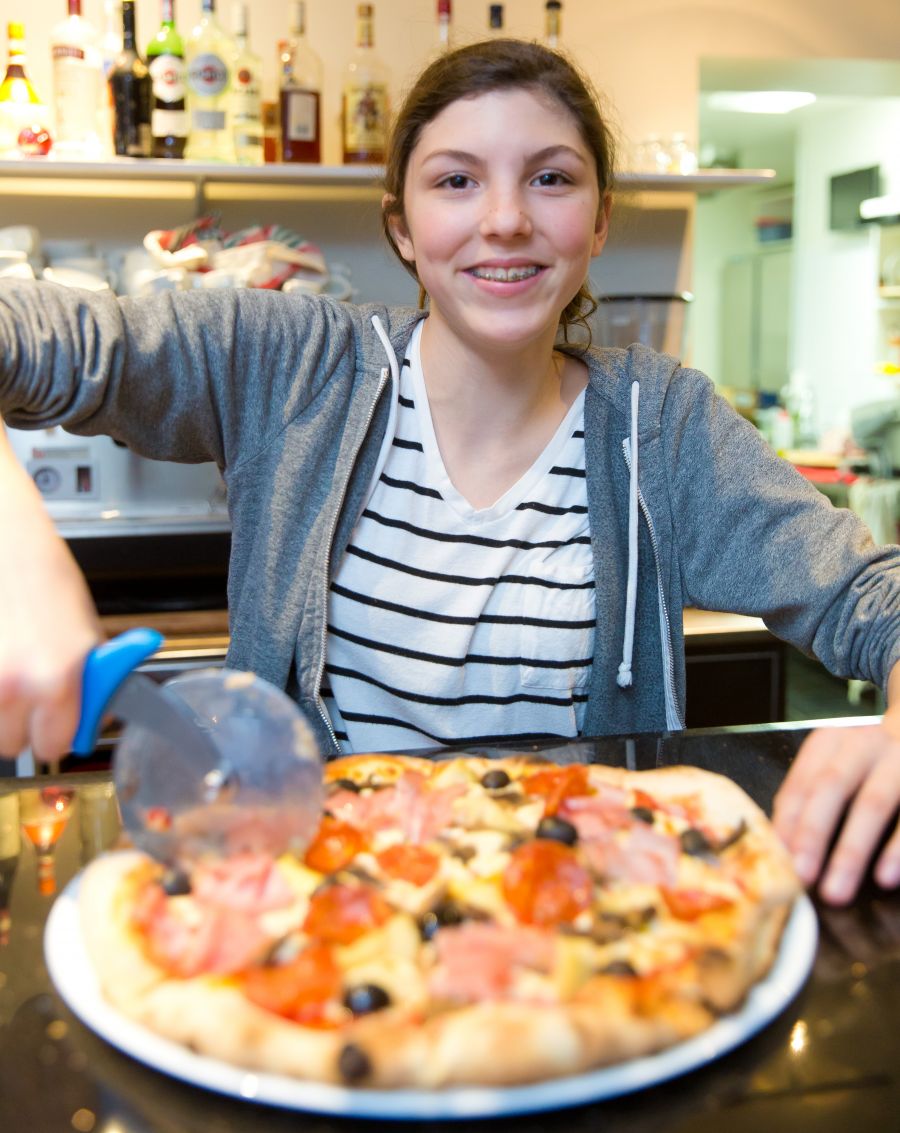 <who>Photo Credit: NowMedia</who>Camilla Ferrari cuts a pizza
