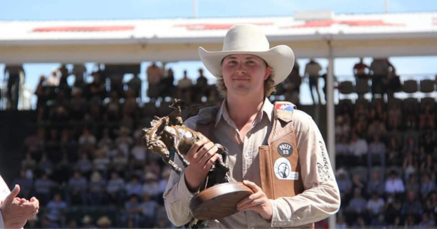 <who> Photo Credit: Jaret Cooper </who> Cooper poses with his trophy after winning the novice saddle bronc event. 