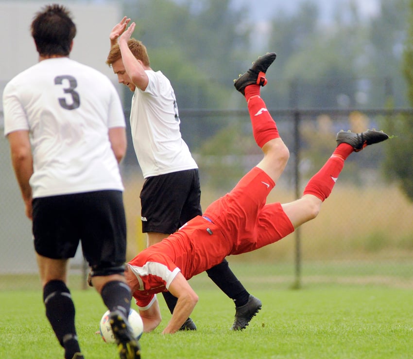 <who>Photo Credit: Lorne White/KelownaNow </who>Pikeys' Adam Rojas takes a tumble while penetrating the Mission Cleaners' zone. Also in on the play are Cleaners' James Byra and Sean Murphy.