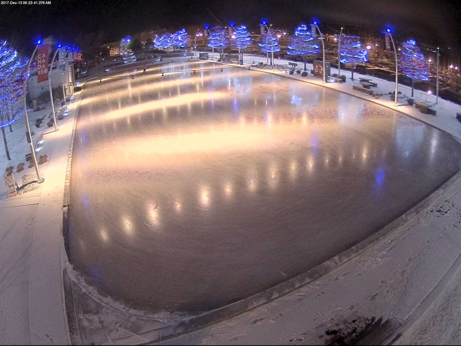 <who>Photo Credit: KelownaNow webcam</who>KelownaNow's Stuart Park webcam shows snow on the ground surrounding the rink.