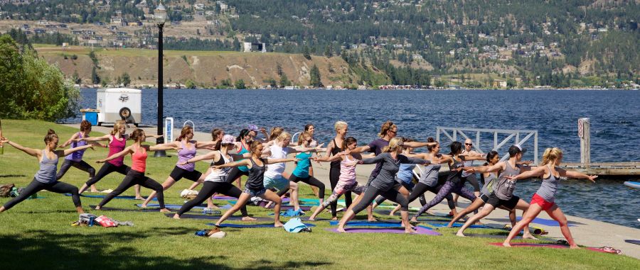 <who> Photo Credit: NowMedia. </who> A group practices yoga in Kelowna City Park. 
