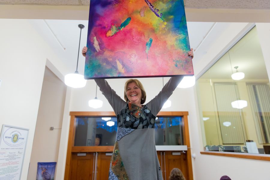 <who> Photo credit: NowMedia </who> Deb Tougas shows of one of her "Feather Series" paintings.