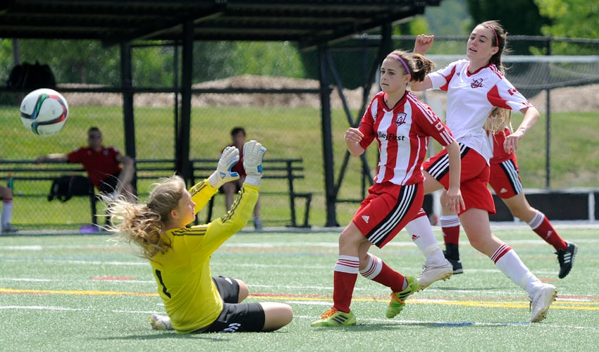 <who>Photo Credit: Lorne White/KelownaNow </who>Logan Finley, right, of the United U16s watches as her shot goes over U15s' goalkeeper Faith Tazalaar. The ball went wide of the net as U15s Payton Hinks looks on.