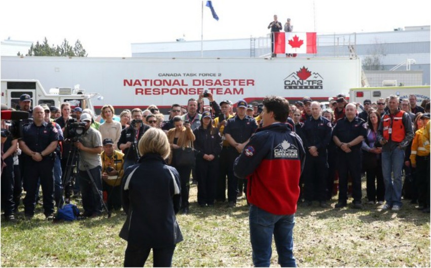 Alberta Premier Rachel Notley and Prime Minister Justin Trudeau speaking to fire crews in Fort McMurray on Friday.