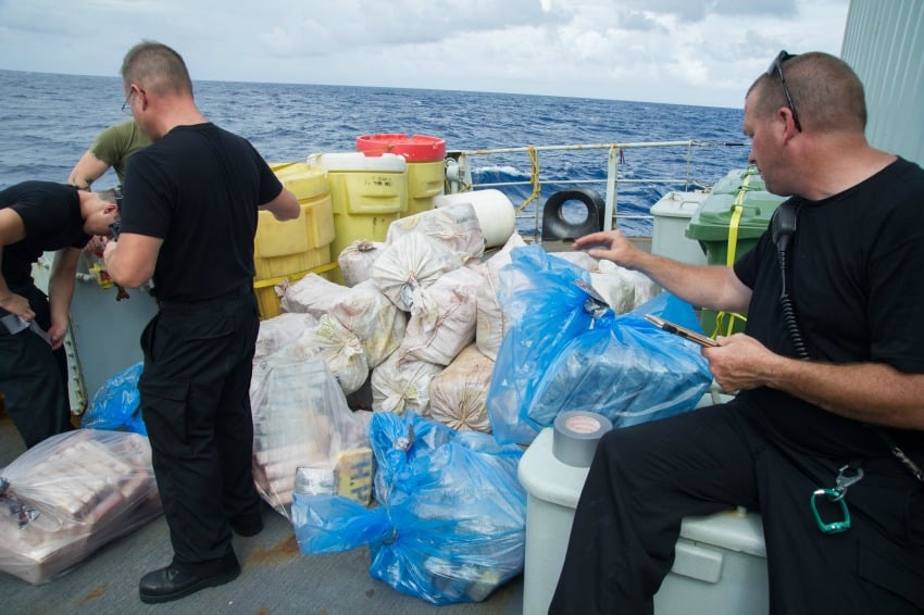<who> Photo Credit: Navy-Marine Forces </who> Crew members from HMCS Moncton mark the drug bundles seized by the United States Coast Guard during Operation CARIBBE in the Caribbean Sea.