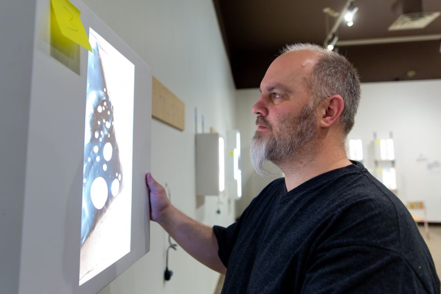 <who>Photo credit: NowMedia</who> Penticton Art Gallery curator Paul Crawford works on the installation.