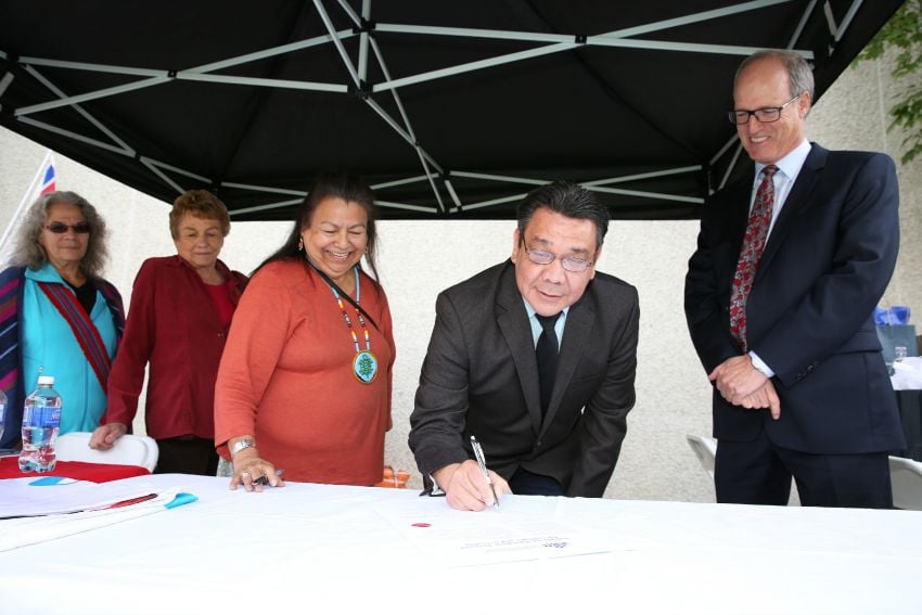 <who> Photo Credit: Okanagan College </who> Okanagan College President Jim Hamilton watches as Okanagan Indian Band Councillor Allan Louis signs the Indigenous Education Protocol. 