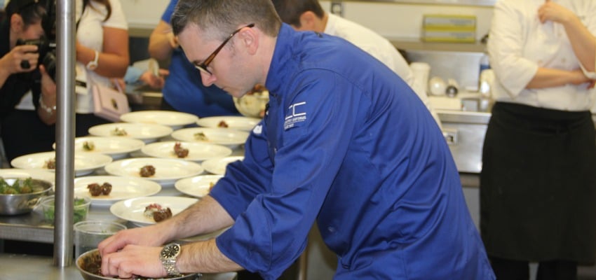 <who> Photo Credit: KelownaNow </who> Ottawa Chef Marc Lepine finishes his dish for the Black Box Competition. 