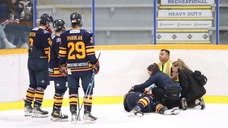 <who> Photo Credit: Chuck Chin </who> Vipers players and trainers surround Blackburn after he collapsed on Saturday night. 